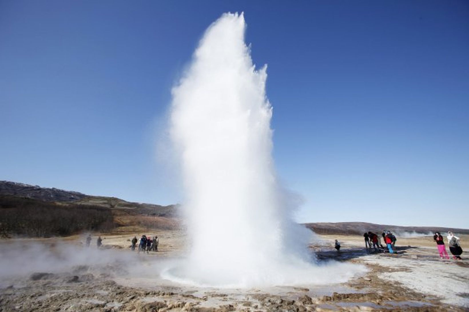 Strokkur geyser erupting with hot water and steam shooting into the air