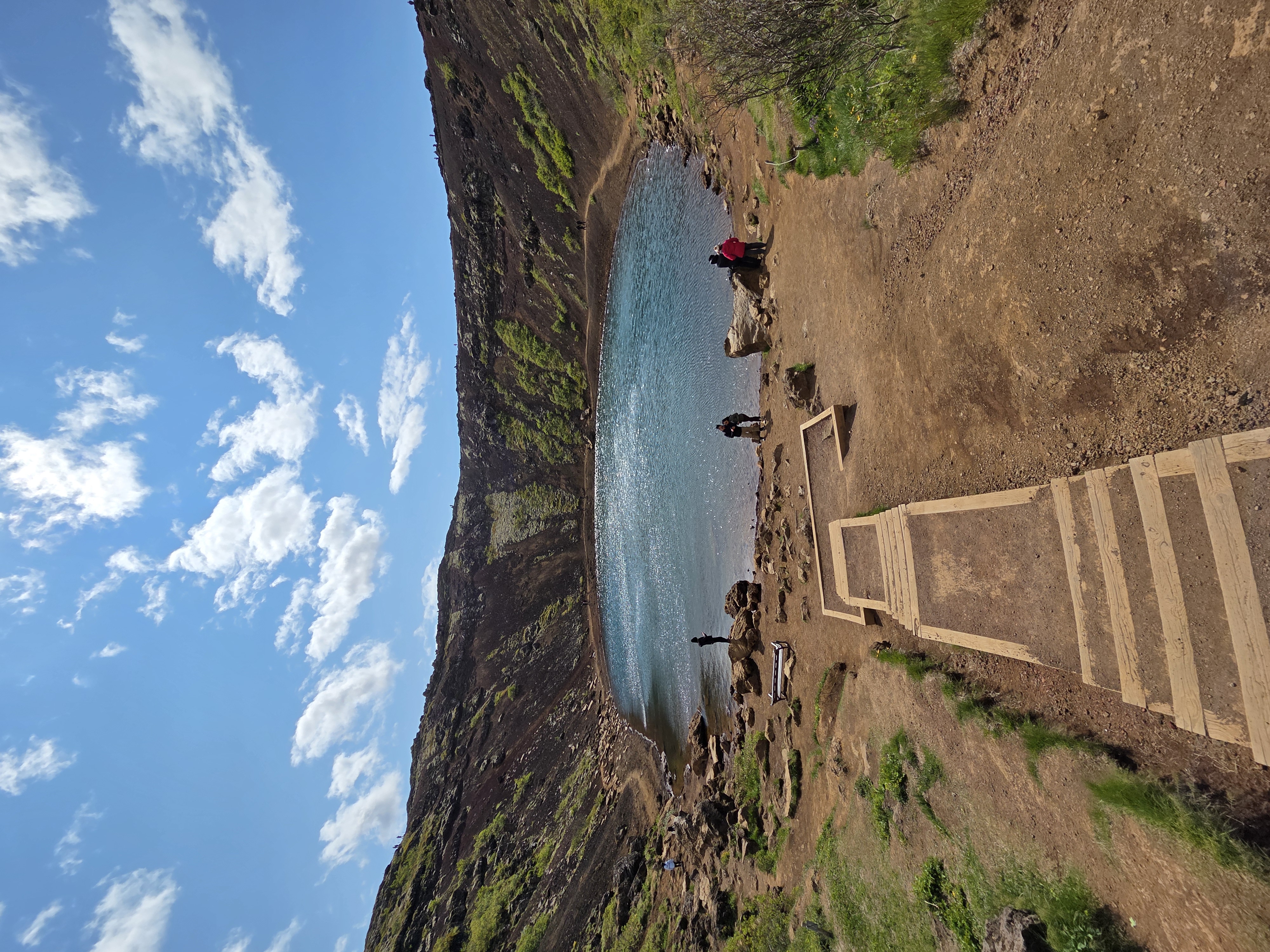 Wooden stairway leading down into Kerið crater with the lake below