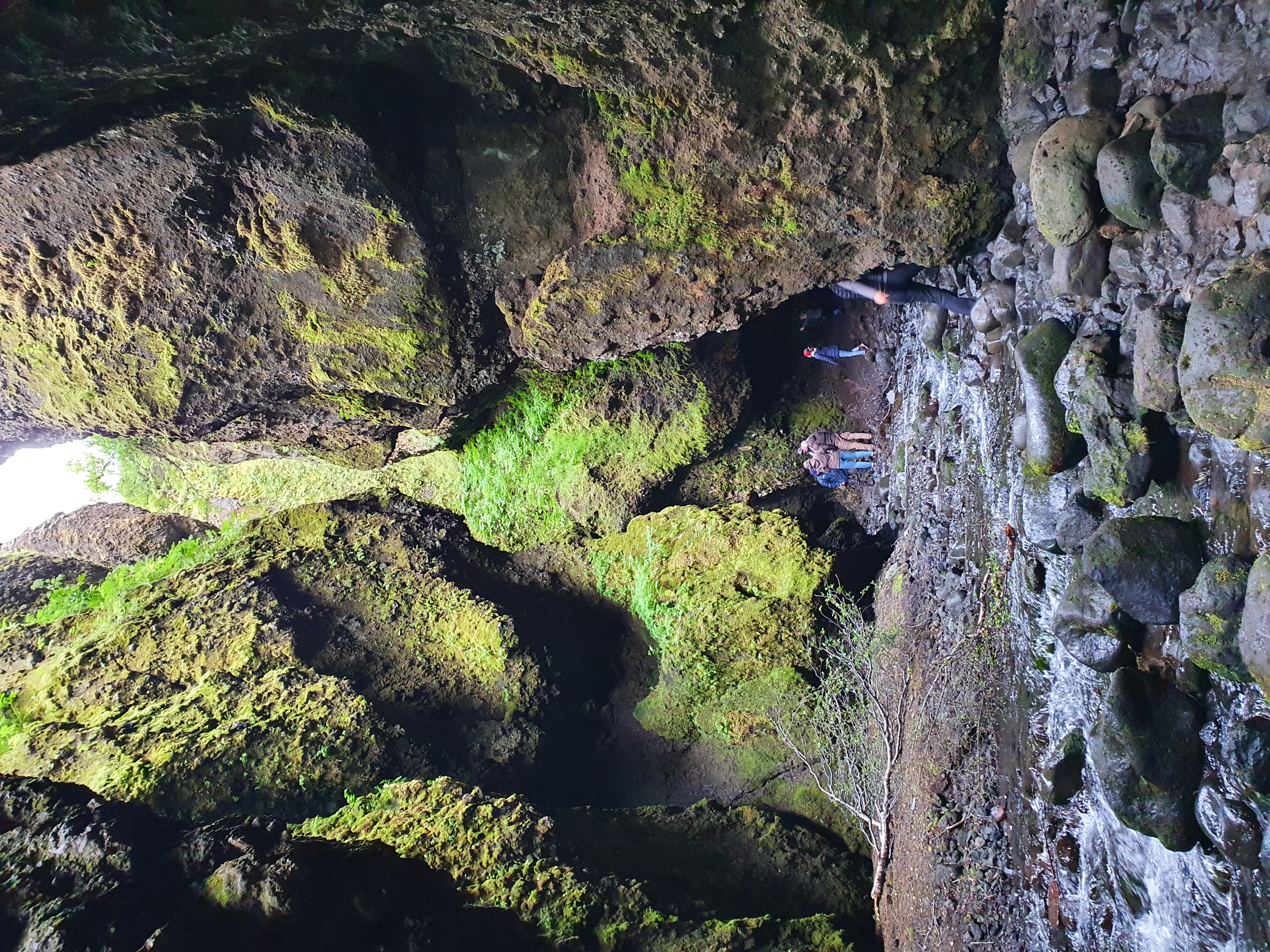 Navigating through the narrow passage deep inside Nauthúsagil ravine