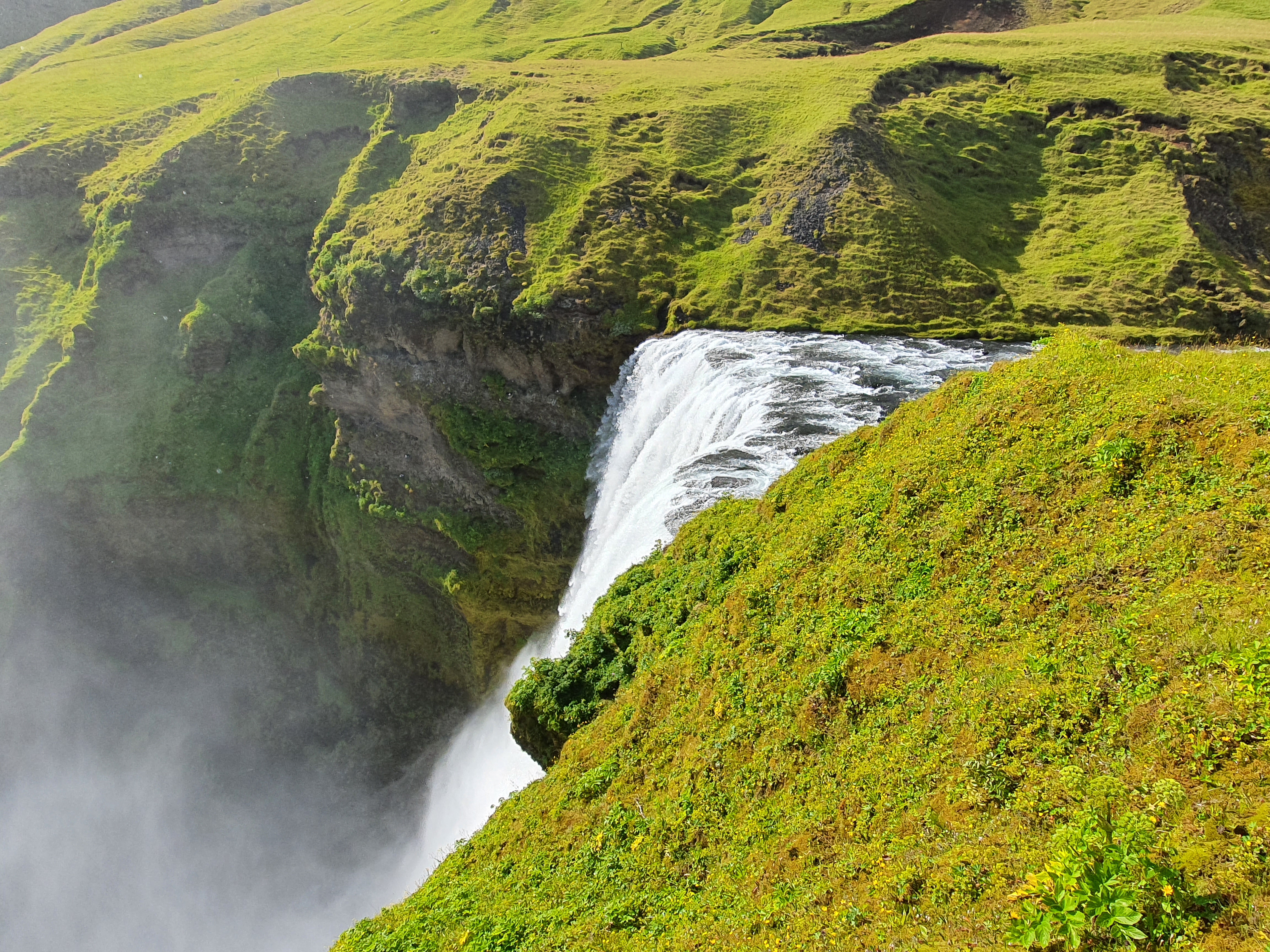 View from the top of Skógafoss looking down the cascade and out to the coast