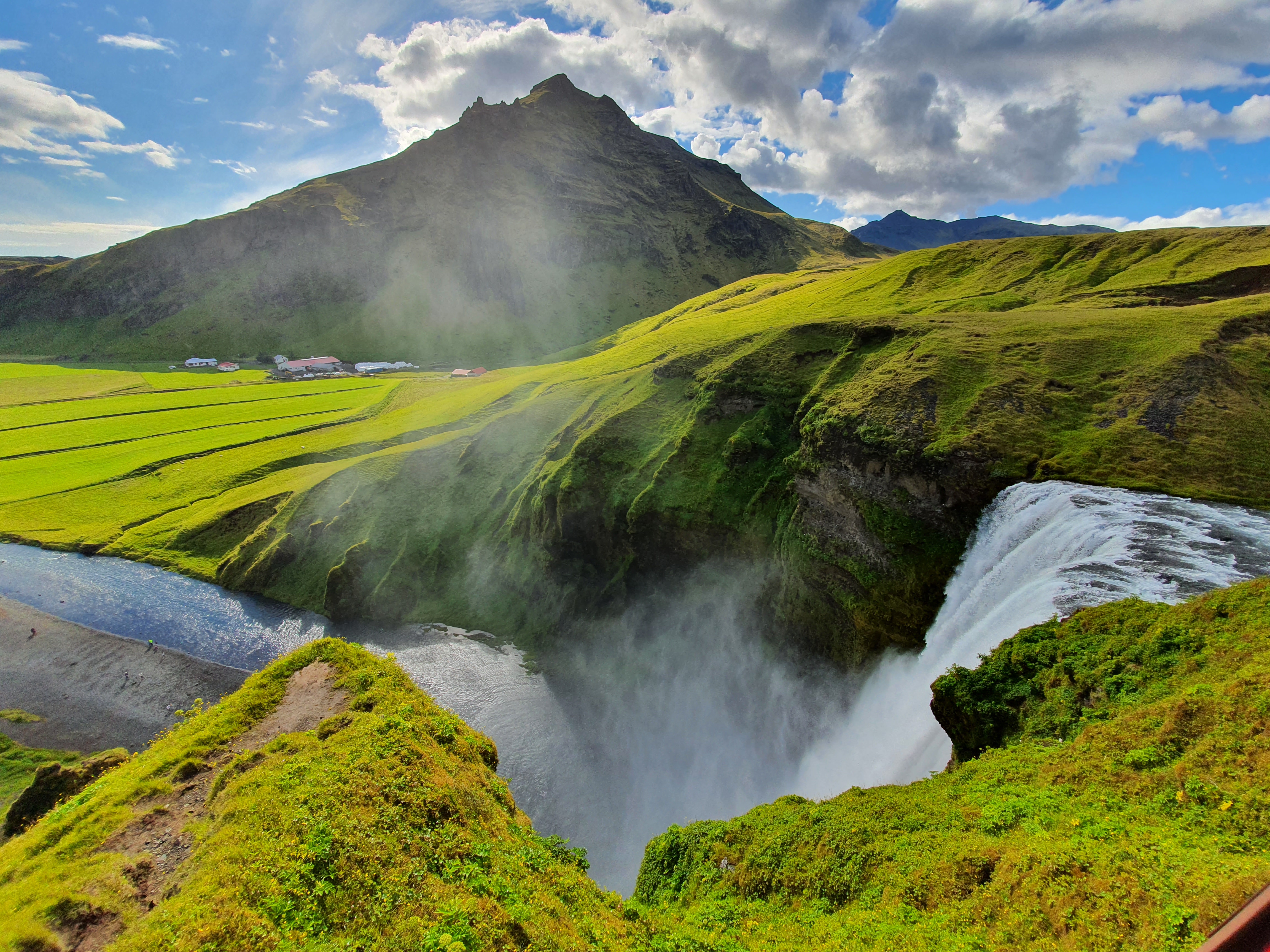 Skógá river above the waterfall with lush green landscape