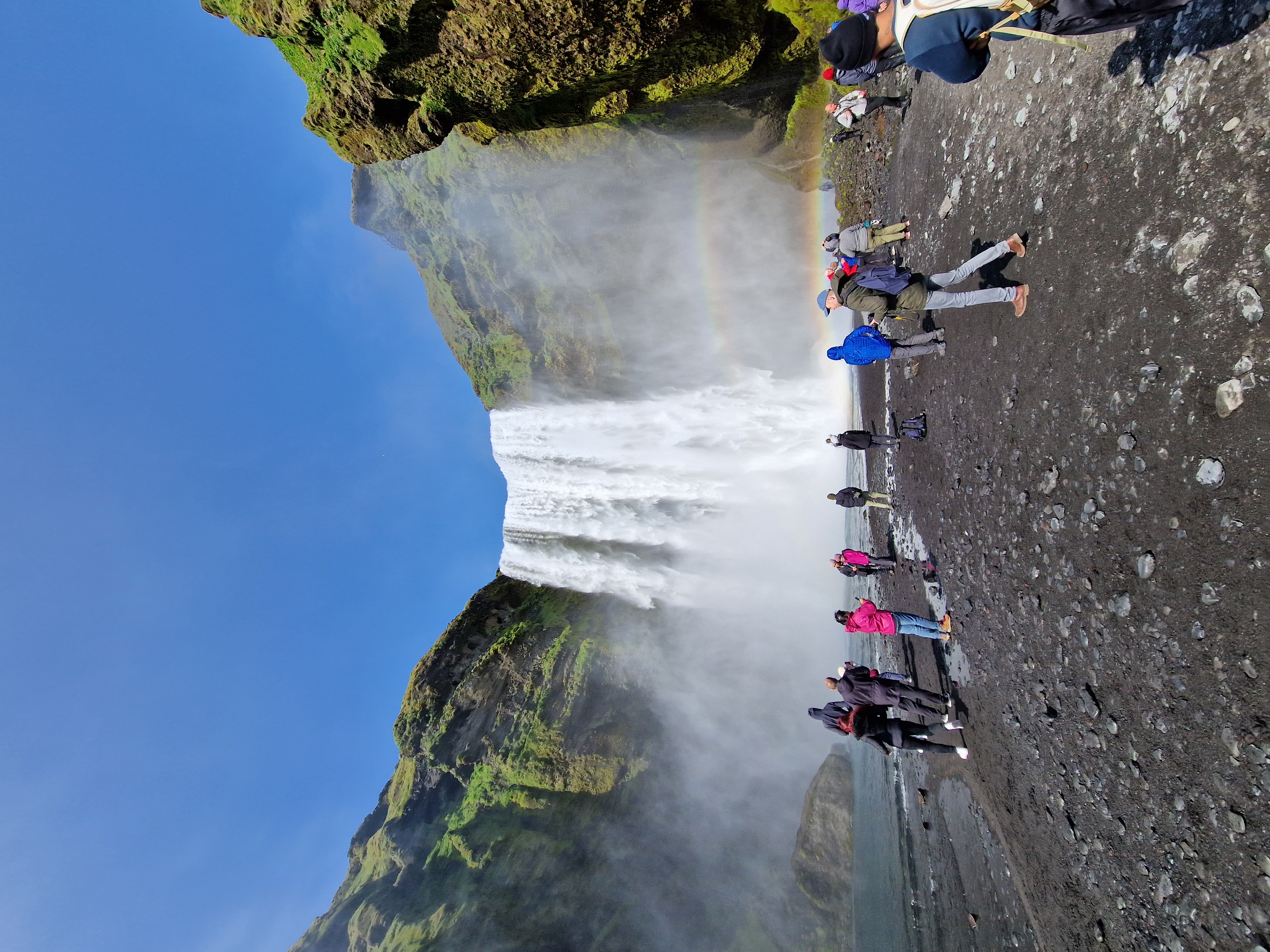 Skógafoss waterfall, a wide curtain of water 60 meters high with rainbow in the mist